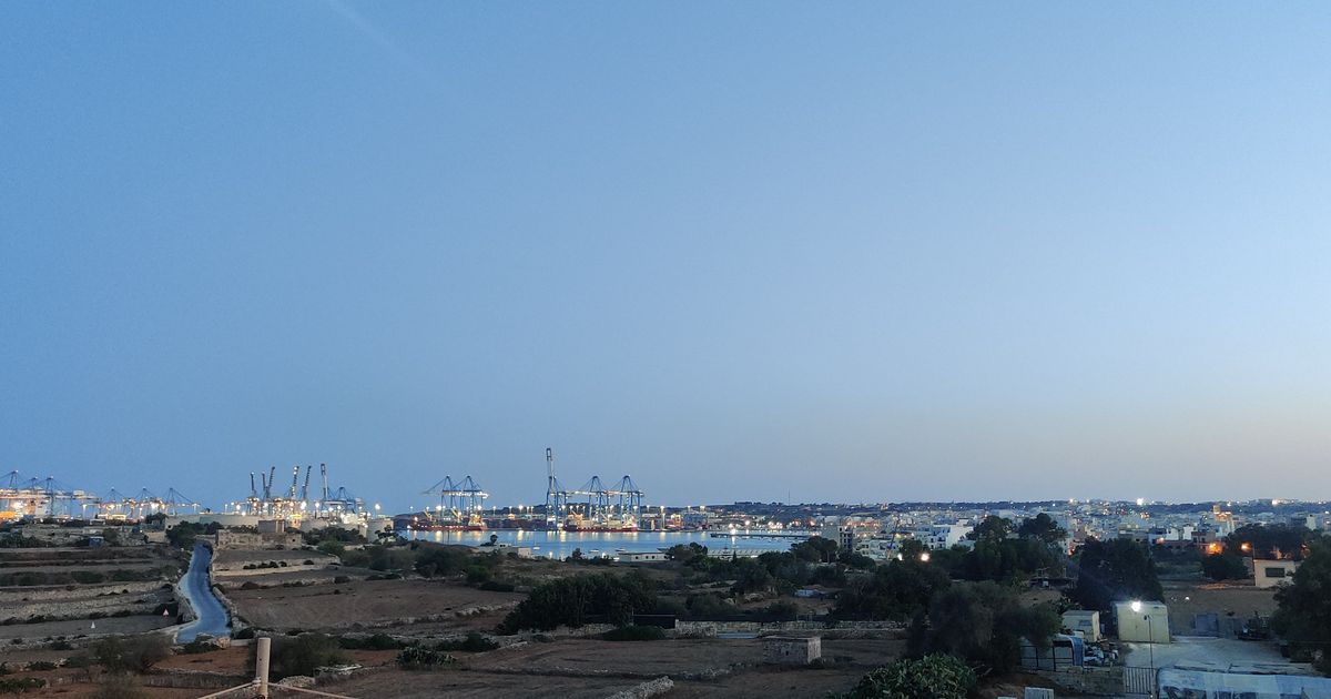 Għelieqi u fl-isfond, il-port.